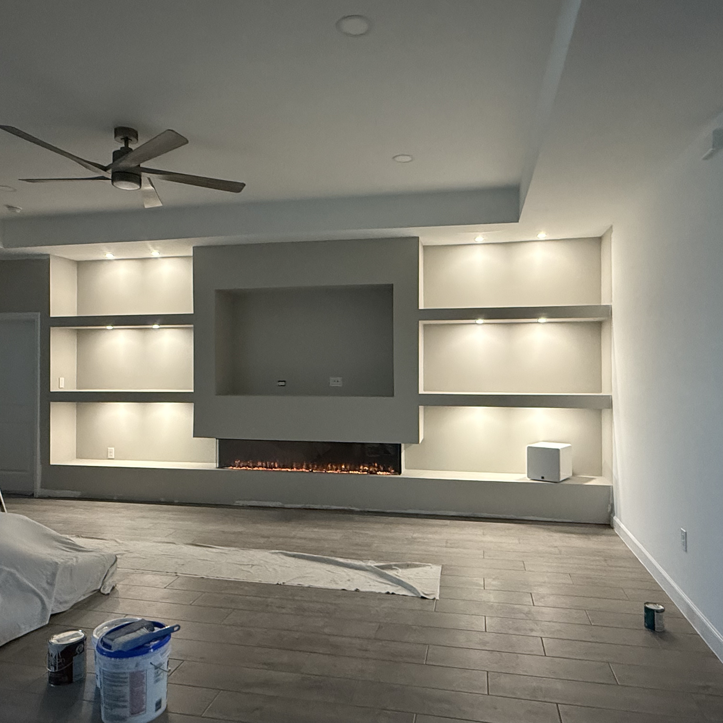 Custom entertainment wall with built-in shelving and electric fireplace